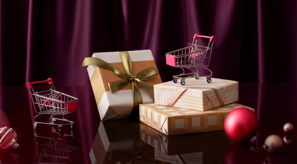 Paquets cadeaux posés sur une table et entourés de décorations et de chariots miniatures