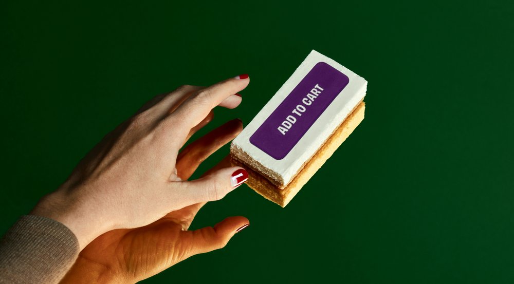Main tendue vers un biscuit décoré d’un bouton indiquant « Ajouter au panier »